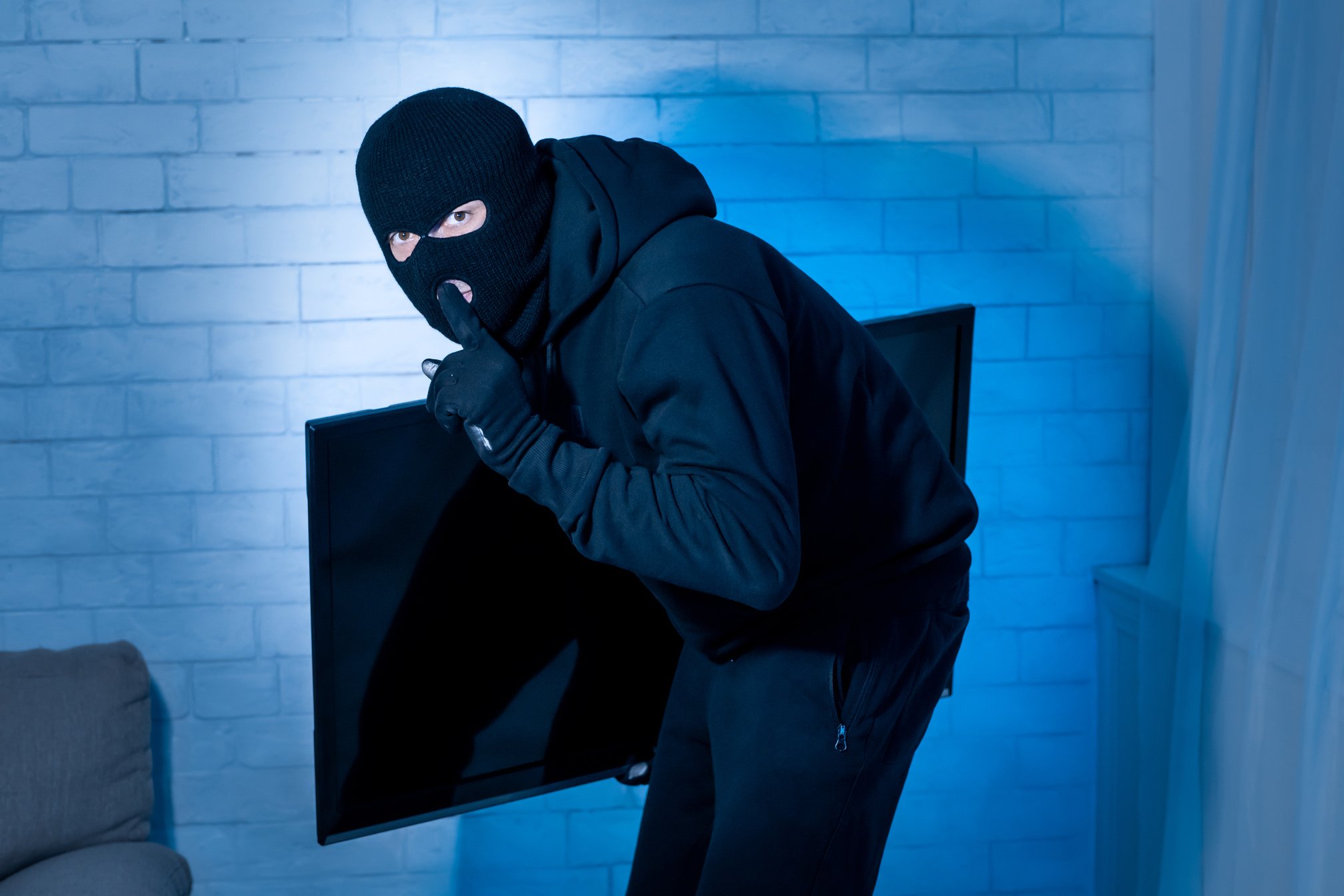 Intruder breaking in an apartment stealing tv